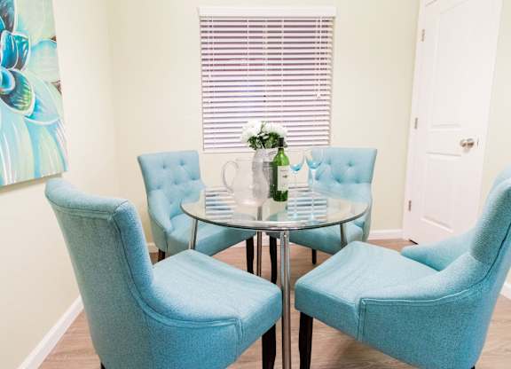 A dining table with four chairs around it.