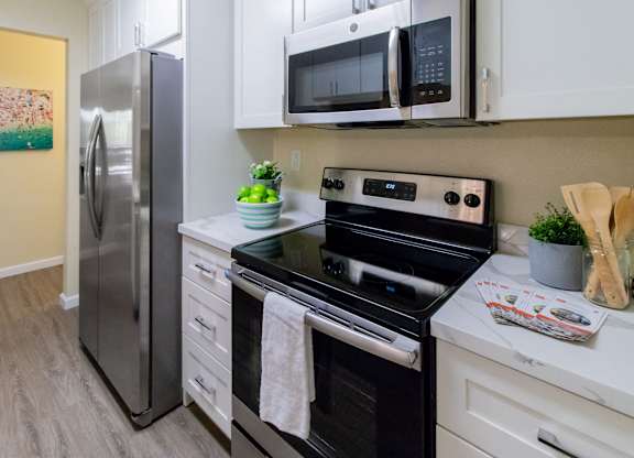 A modern kitchen with a stainless steel refrigerator, oven, and microwave.