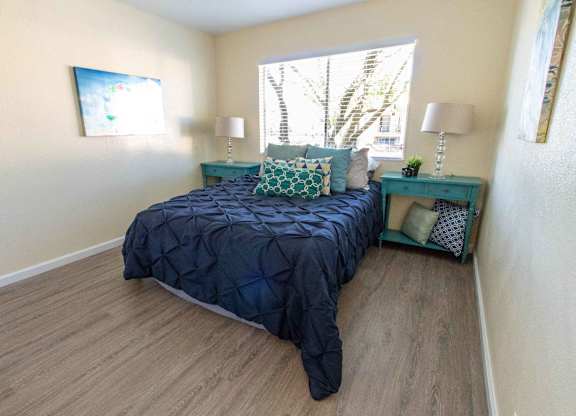A bedroom with a bed, nightstand, and lamp.
