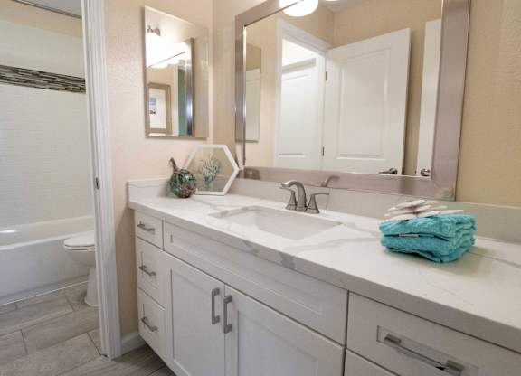 A white bathroom with a white tub and sink.