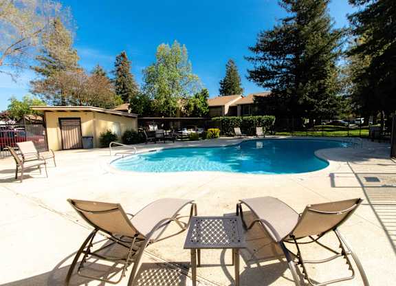 A pool with chairs around it.