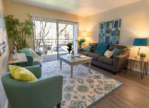 A living room with a green chair and a grey couch.