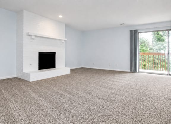 A white room with a fireplace and carpeted floor.