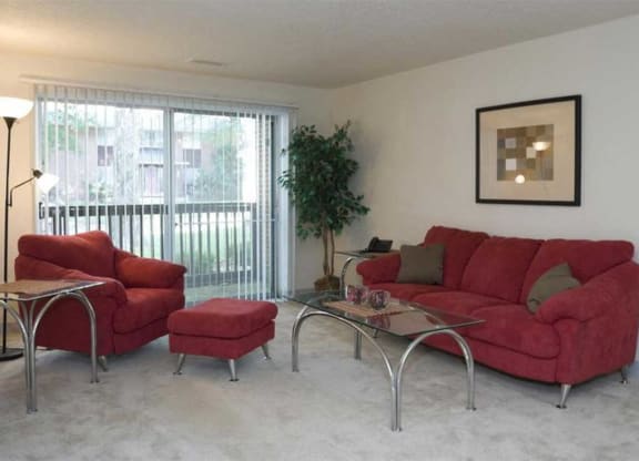 a living room with a red couch and chair and a sliding glass door at Waldo Heights, Kansas City