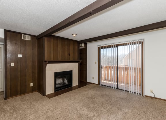 West One Bedroom Living Room, Fireplace, and Balcony Door at Raintree Apartments, Topeka, KS, 66614