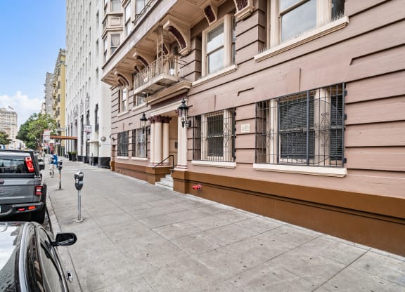 a street view of a building with a sidewalk and a parking meter