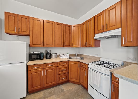 a kitchen with white appliances and wooden cabinets