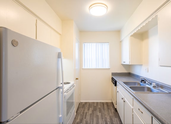 A small kitchen with white appliances and cabinets.