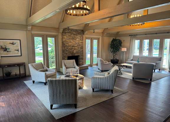 A living room with a stone fireplace and striped armchairs.