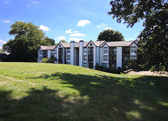 A row of white houses with green lawns in front.