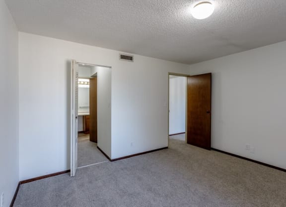 a bedroom with white walls and carpet