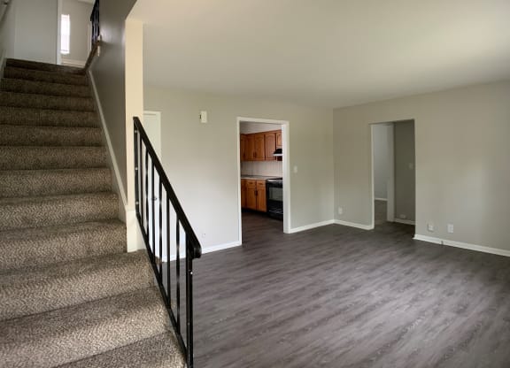 Spacious living room with open concept to kitchen and stairs