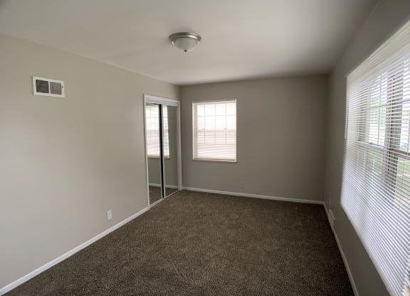Spacious bed room with mirrored closets and 2 windows