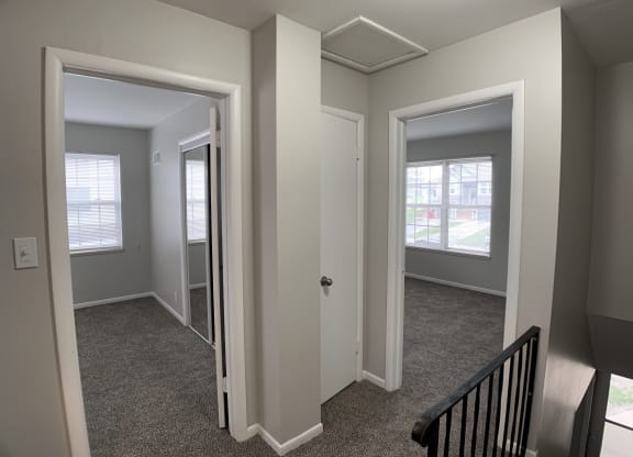 View of 2 bedrooms from top of stairs