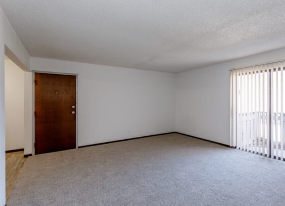 an empty bedroom with a door leading to a balcony
