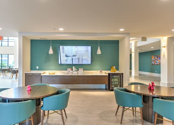 a dining room with tables and chairs and a tv on the wall at Pinnacle Apartments, Florida, 32256