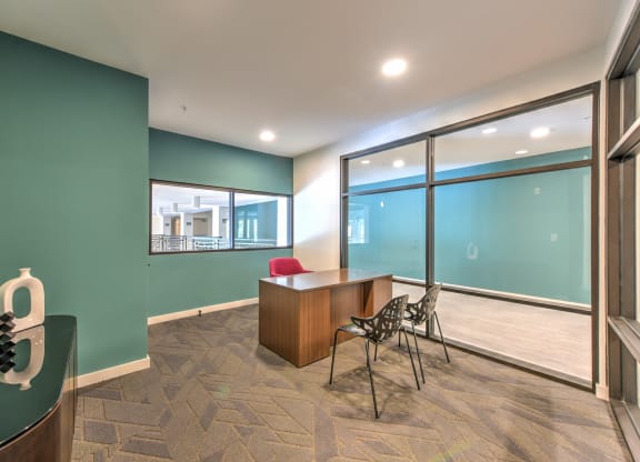a conference room with large windows and a desk and chairs at Pinnacle Apartments, Jacksonville, 32256