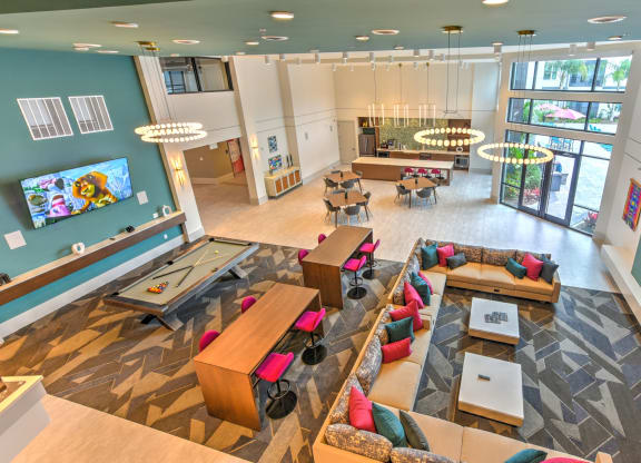 a large lobby with couches and tables and a tv at Pinnacle Apartments, Florida, 32256