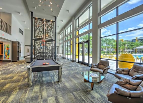 a large room with a pool table and a lot of windows  at Fusion, Jacksonville, FL, 32256