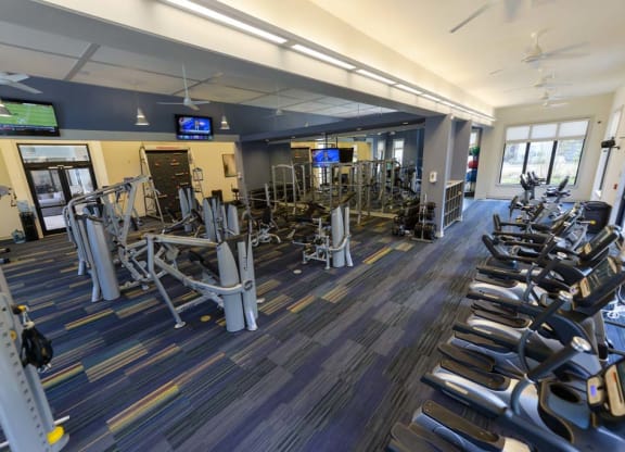 a large fitness room with cardio equipment and flat screen tvs  at Cabana Club - Galleria Club, Jacksonville, Florida