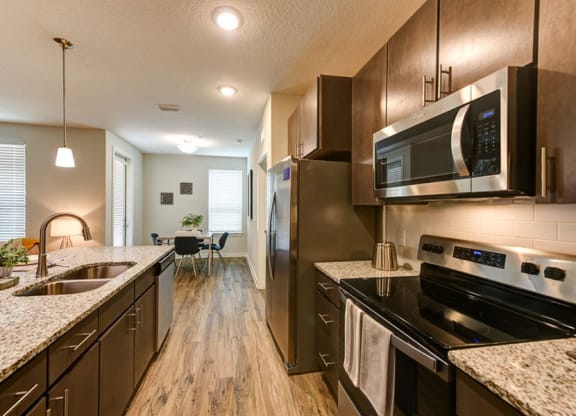 a kitchen with a stove top oven next to a sink  at Fusion, Florida, 32256