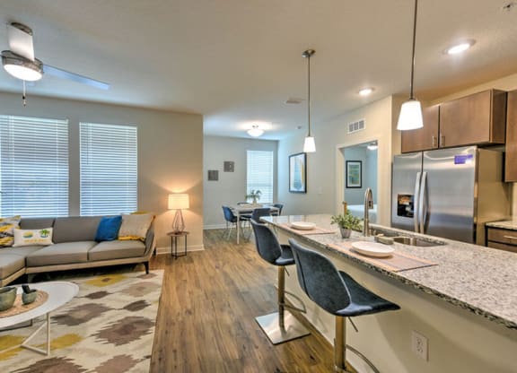 a living room and kitchen area with a couch and a table  at Fusion, Jacksonville, FL