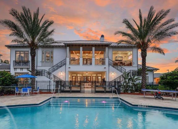 a large white house with a pool in front of it  at Palm Bay Club, Florida, 32258