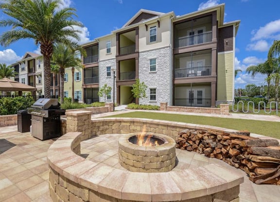 a fire pit with a grill in front of an apartment building  at Cabana Club - Galleria Club, Jacksonville
