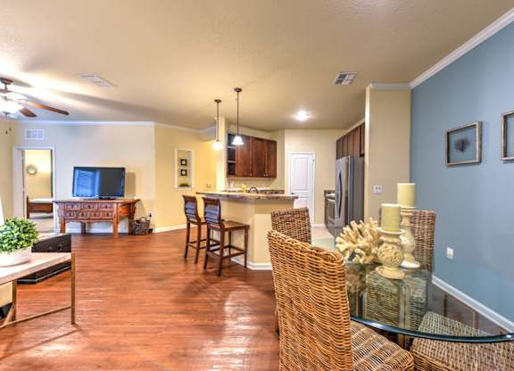 A living room with a glass table and wicker chairs at Cabana Club - Galleria Club Apartments, Florida