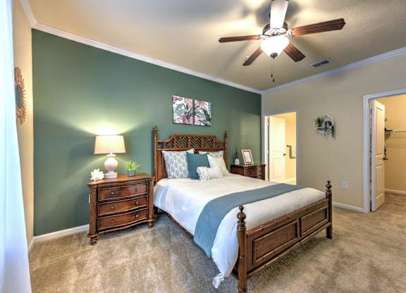A bedroom with a bed, dresser, and ceiling fan at Cabana Club - Galleria Club Apartments, Jacksonville, Florida