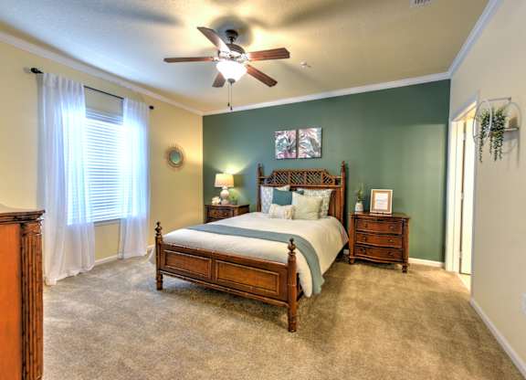 A bedroom with a bed, dresser, and window at Cabana Club - Galleria Club Apartments, Jacksonville, FL, 32256