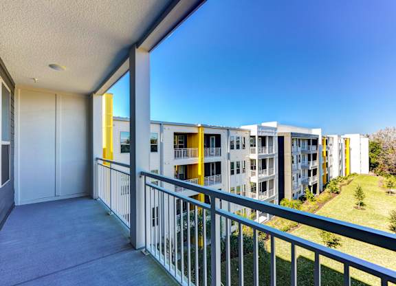 A balcony with a metal railing and a view of apartment buildings at Fusion Apartments, Jacksonville, FL