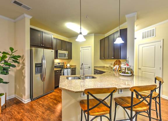 A kitchen with a refrigerator, microwave, oven, sink, and cabinets at Cabana Club - Galleria Club Apartments, Florida