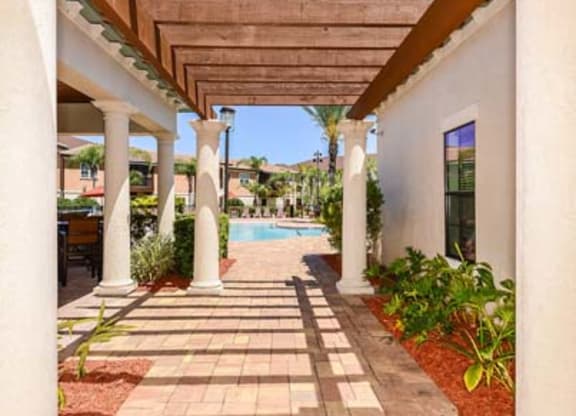 a covered walkway with a pool in the background  at Hacienda Club, Jacksonville, 32256