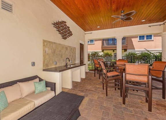 a living room with a couch a table and a ceiling fan  at Hacienda Club, Jacksonville, FL
