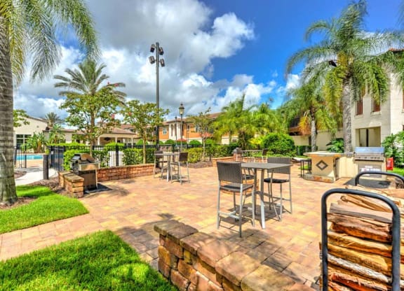 a patio with tables and chairs and a pool in the background  at Hacienda Club, Jacksonville