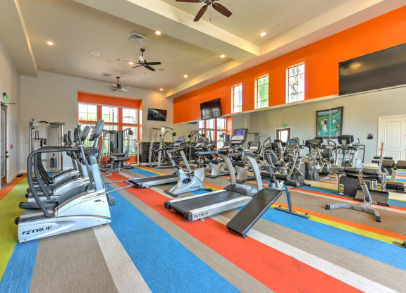 a gym with treadmills and other exercise equipment and windows at Hacienda Club, Jacksonville, Florida