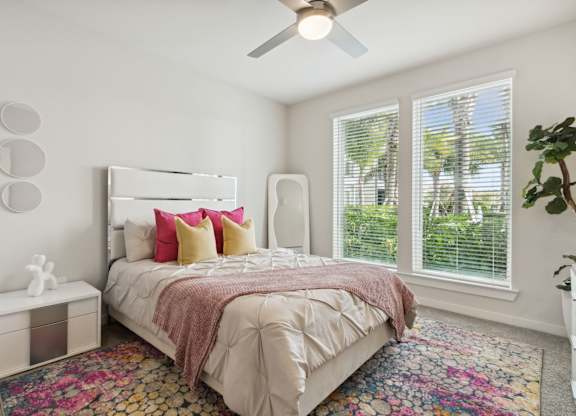 A bedroom with a large bed and a ceiling fan. at Pinnacle Apartments, Jacksonville, 32256
