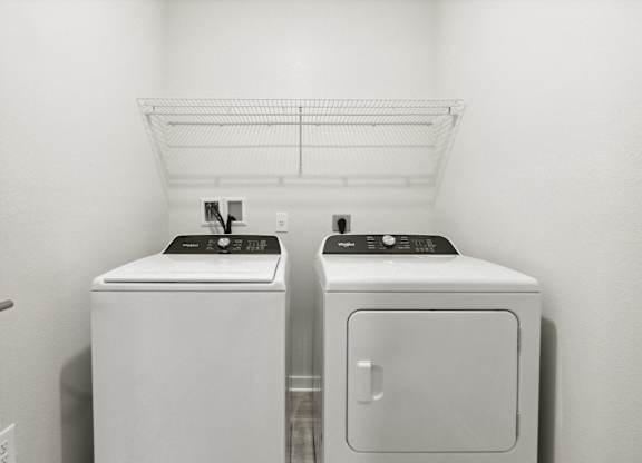 A white bathroom with a washer and dryerat Pinnacle Apartments, Jacksonville, FL