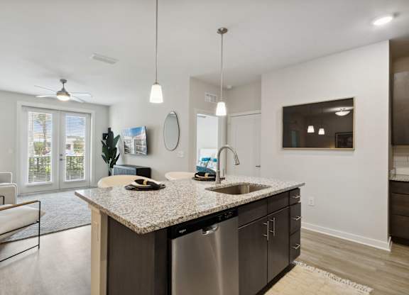 A modern kitchen with a granite countertop and stainless steel appliancesat Pinnacle Apartments, Jacksonville, FL