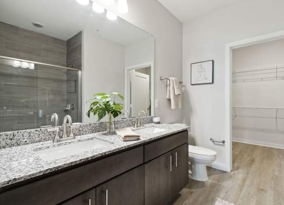 A bathroom with a marble countertop and a walk-in showerat Pinnacle Apartments, Jacksonville, FL