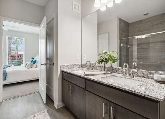 A bathroom with a double sink vanity and a mirror above itat Pinnacle Apartments, Jacksonville, FL