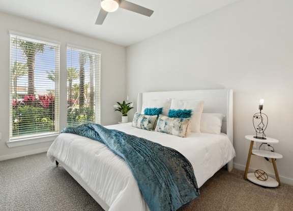 A bedroom with a bed, a fan, and a window with blindsat Pinnacle Apartments, Jacksonville, FL