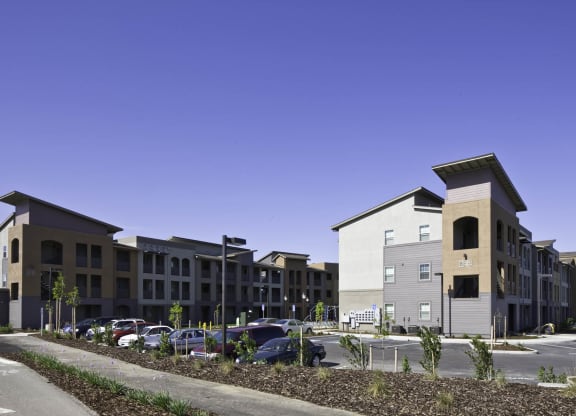 New Harmony Mutual Housing Community building exteriors and parking lot photographed from a distance