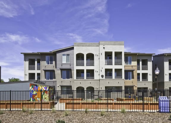New Harmony Mutual Housing Community building in background, community garden in mid-ground, Davis bike loop bike path in forground