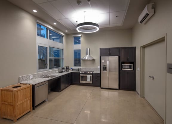Kitchen in Community room with stainless steel appliances and dark cabinets