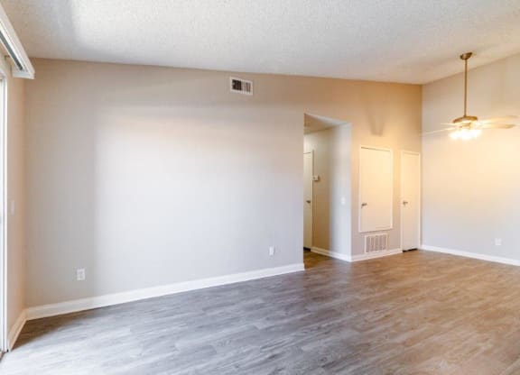 an empty living room with white walls and a wood floor