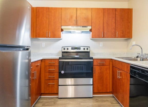 a kitchen with stainless steel appliances and wooden cabinets