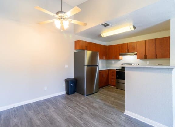 a kitchen with a refrigerator and a ceiling fan