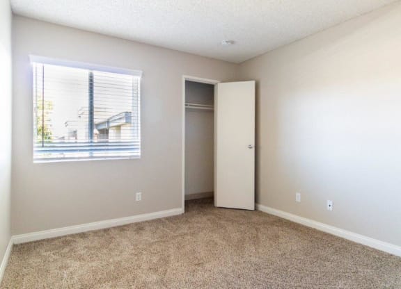 an empty room with a window and a closet